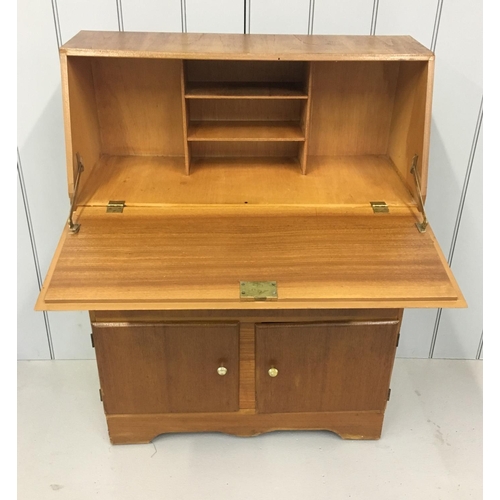 63 - A light-wood bureau. Drop-down desk area above double drawers, in turn over a double cupboard.
Dimen... 