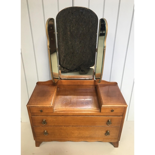 102 - An Oak Dressing Table with Triple Mirror. A tri-fold mirror sits above a 4-drawered dressing area.
D... 