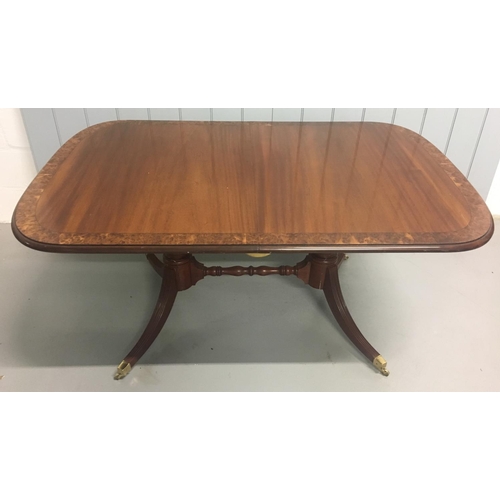 100 - An impressive, extending, veneered dining table.
Oval shaped, with extension leaf and brass castors.... 