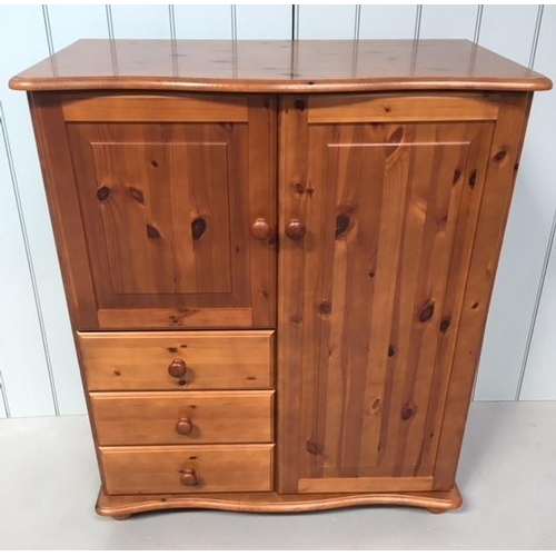 89 - A Duckers pine tallboy. Tall, single cupboard alongside a shorter cupboard, over 3 single drawers. T... 