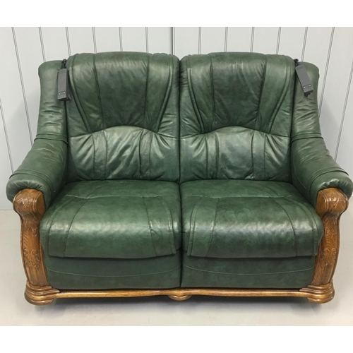 98 - A quality green leather suite, with oak surround. A two seater sofa and two armchairs. Each is a rec... 