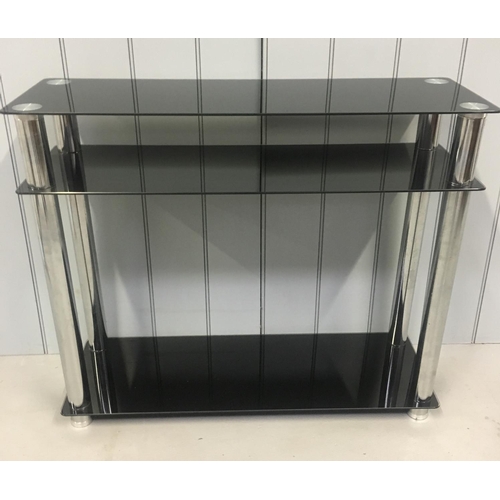 212 - A modern console table, with black-glass shelves, supported by chrome coloured legs.
Dimensions(cm) ... 