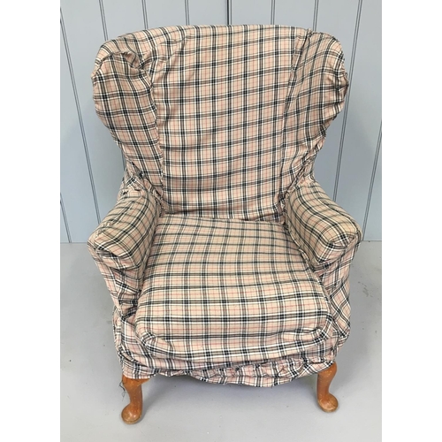 181 - A classic Parker Knoll winged armchair. Model PK 720. The chair is loosely covered in check fabric.
... 