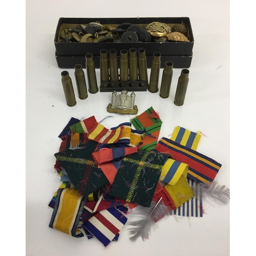 304 - A mixed lot of military items. Includes 15 spent shell cases, Cambridgeshire regiment cap badge, med... 