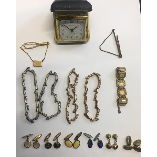 327 - A mixed lot of costume jewellery & a vintage travel alarm clock.
Includes 6 pairs of cufflinks, 5 br... 