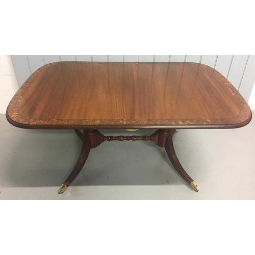 538 - An impressive, extending, veneered dining table.
Oval shaped, with extension leaf and brass castors.... 