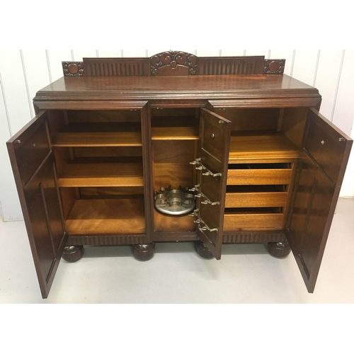 577 - A solid oak buffet-style sideboard/drinks cabinet.
Three brass-handled cupboards incorporating shelv... 