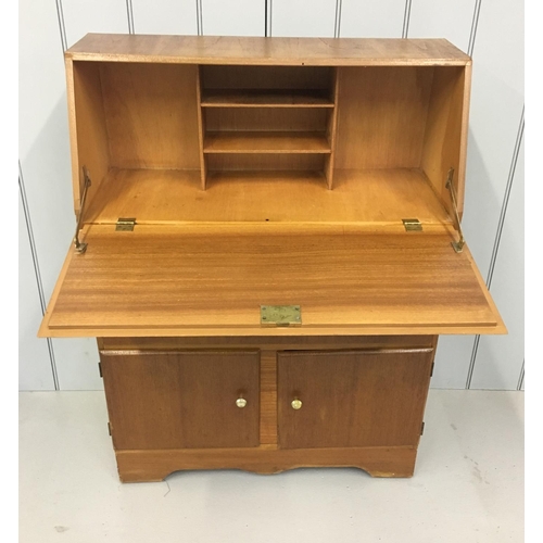 601 - A light-wood bureau. Drop-down desk area above double drawers, in turn over a double cupboard.
Dimen... 