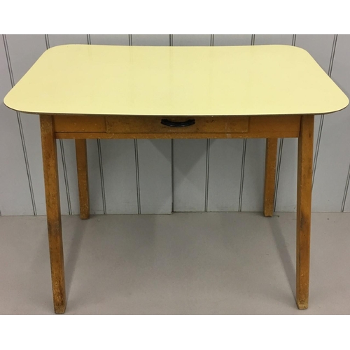 242 - A retro Formica kitchen table.
Yellow Formica table-top above a single drawer, sitting on splayed le... 