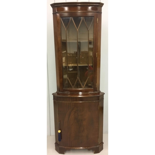 704 - A tall mahogany corner/display cabinet.
Edwardian-style glass door above bow-fronted cupboard. Key p... 