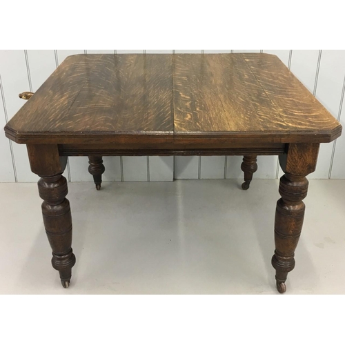 591 - An extendable Edwardian dining table, with one extension leaf.
Wind-out mechanism, with original han... 