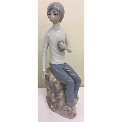 234 - A Spanish porcelain figurine of a Boy Seated, from Casades.
Height 21cm