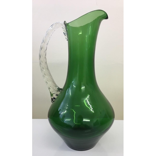 590 - A vintage blown glass pitcher.
Green glass, with clear glass handle.
29cm tall