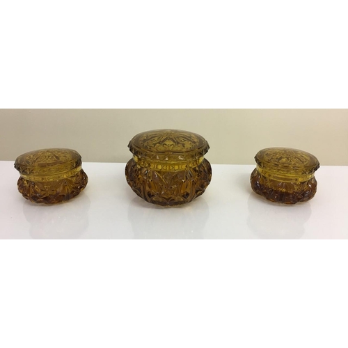601 - An early Amber glass Dressing Table set. Includes tray, ring holder & three lidded trinket pots (2 s... 