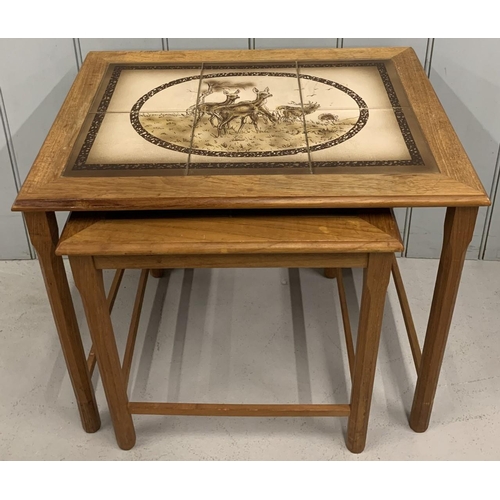 9A - A mid-century,  nest of 2 tiled tables, with dear scenes.
Largest dimensions(cm) H47 W55 D40.