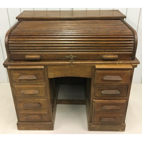 103 - Stunning Oak Roll-Top Desk. Kneehole flanked by two four-drawer pedestals, both with writing leaves.... 