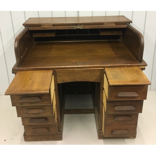 103 - Stunning Oak Roll-Top Desk. Kneehole flanked by two four-drawer pedestals, both with writing leaves.... 