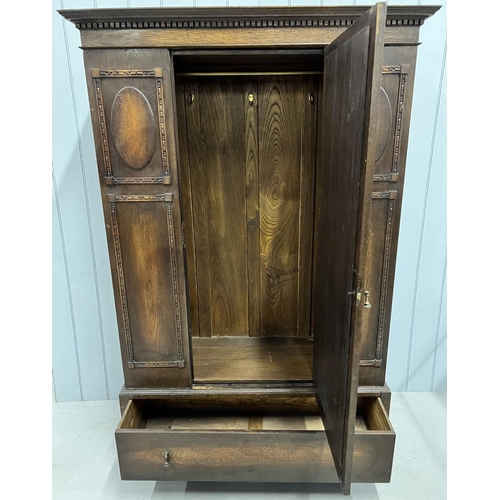 63 - An Edwardian, oak double wardrobe. Cental mirrored door, with internal hanging rail, over a single d... 