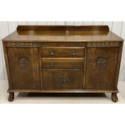 76 - An oak buffet sideboard.
Two door cupboard with central cutlery drawer & another, over a narrow cupb... 