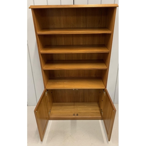 87 - A teak-veneered upright bookcase with two-door cupboard. Made by James H Sutcliffe & Son Ltd.
Dimens... 