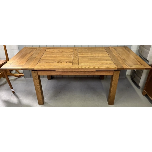 18 - A solid oak extending dining table. Two self-contained extension leaves. Dimensions 9cm) H79, W140/2... 