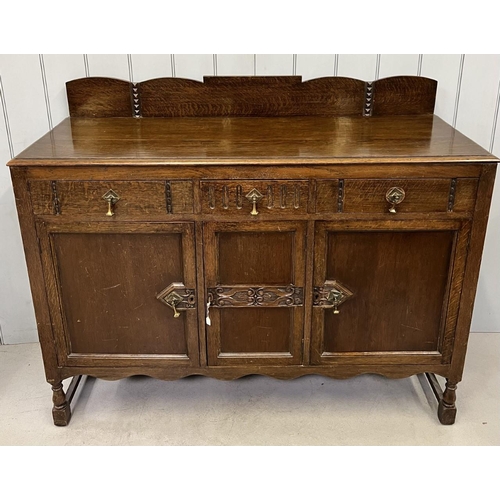 52 - An Edwardian oak buffet sideboard. Three drawers, over triple cupboard. Central cutlery drawer. Key ... 