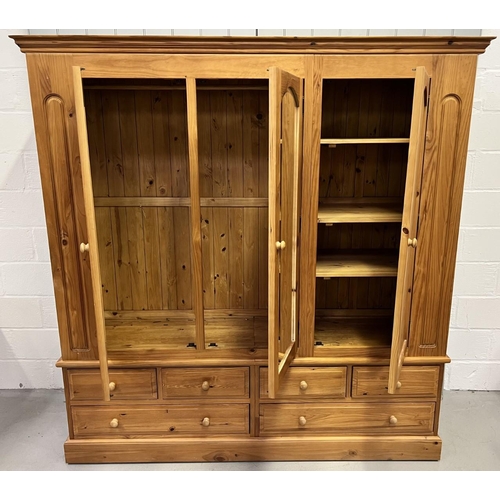 53 - A stunning, solid pine triple wardrobe. Wardrobe sits upon a base of six drawers. Central mirrored d... 