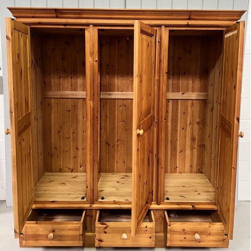 57 - A solid pine triple wardrobe, with full width hanging rail, three drawers/doors. Dimensions(cm) H190... 