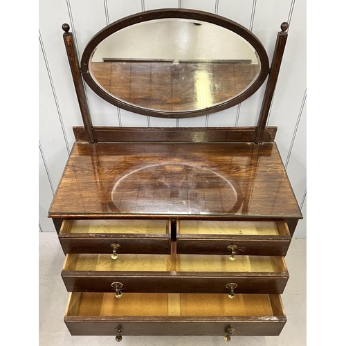 68 - A vintage dressing table. Two over three drawers, with oval swing mirror. Brass handles & castors. G... 