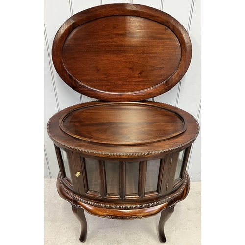 82 - A Regency-style, oval-shaped, mahogany glazed drinks cabinet with twin doors & detachable tray.
Dime... 