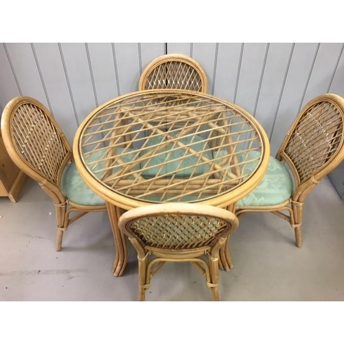 12 - A bamboo & cane dining table & four chairs. Circular, glass-topped table, with cushioned chairs. Dim... 