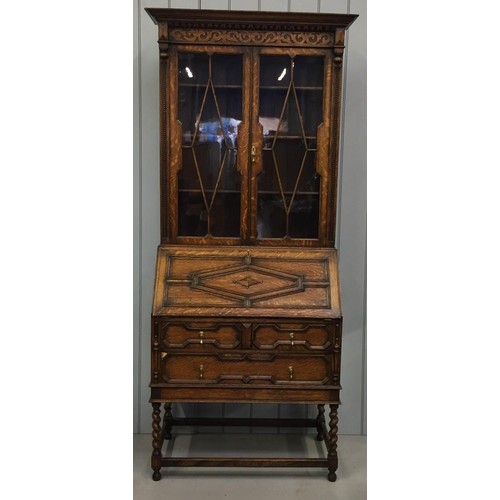 39 - An Edwardian bureau bookcase. Glazed/shelved cupboard over fall front fitted desk area, on barley-tw... 