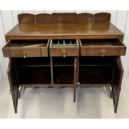 52 - An Edwardian oak buffet sideboard. Three drawers, over triple cupboard. Central cutlery drawer. Key ... 