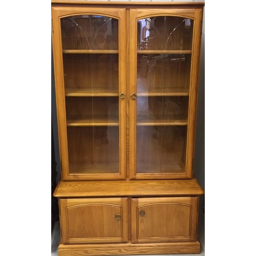 63 - An Ercol-style display cabinet. Glazed shelves, over two-door cupboard area. Dimensions(cm) H157, W9... 