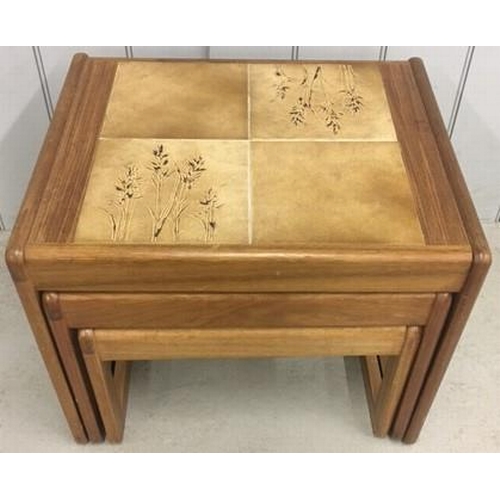 125 - A mid-century, teak/tiled nest of three tables, by Sunelm. Largest dimensions(cm) H42, W54, D46.