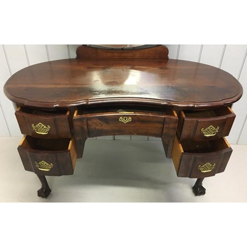 58 - A beautiful, kidney-shaped mahogany dressing table. Five drawers, with brass handles, supported by c... 