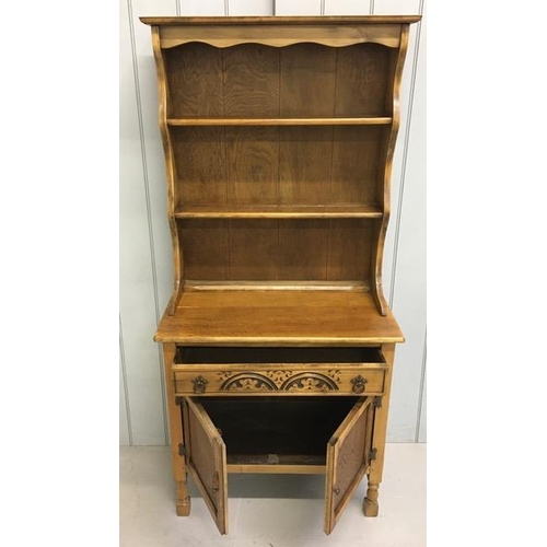 42 - An early 20th century Arts & Crafts oak dresser. Two plate rack shelves over a single, carved drawer... 