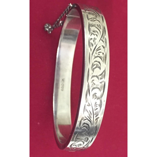 409 - A hallmarked, sterling silver bangle, with safety chain. Weight approx. 20g.