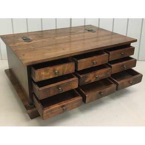 11 - A contemporary Sheesham wood coffee table, having hinged half lid over a set of nine apothecary styl... 