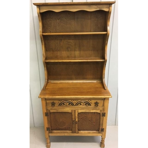 42 - An early 20th century Arts & Crafts oak dresser. Two plate rack shelves over a single, carved drawer... 