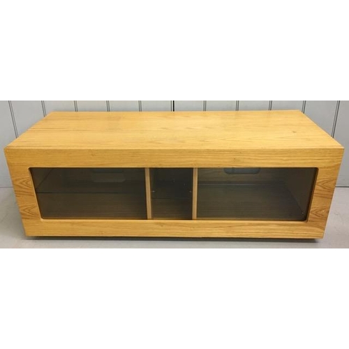 134 - A fall-front, beech TV unit, with three internal glass shelves. Dimensions(cm) H40, W115, D47.