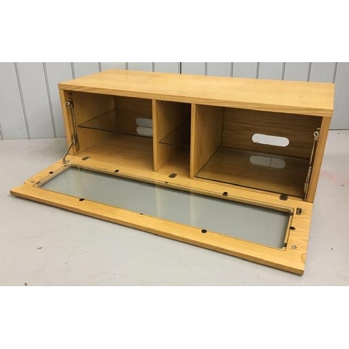 134 - A fall-front, beech TV unit, with three internal glass shelves. Dimensions(cm) H40, W115, D47.