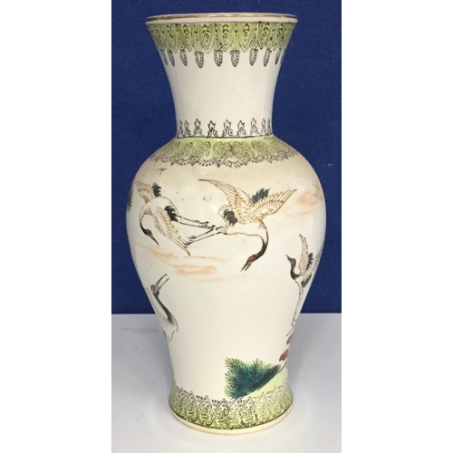 541 - A pretty oriental vase, depicting Cranes in flight. Height 27cm.