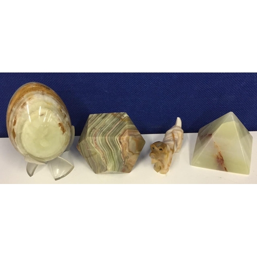 585 - A collection of four ornamental Onyx items. Includes egg on stand, pyramid, dog figure & 14-sided pa... 