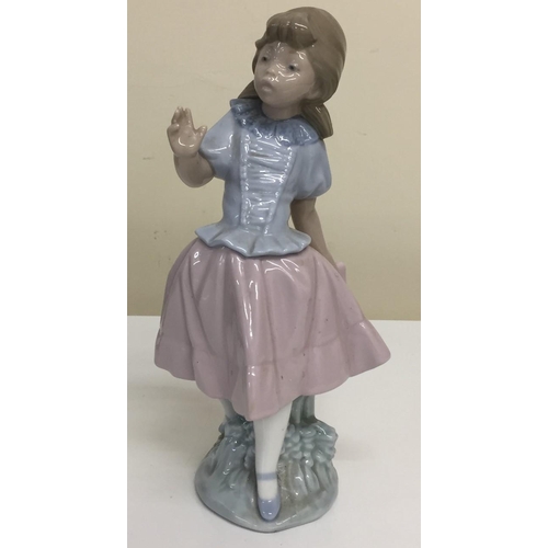 587 - A Lladro Nao figurine - 'Pretty Young Girl Holding Skirt'.