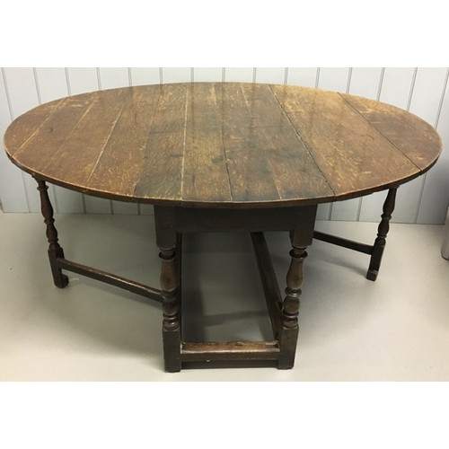 30 - An 18th century oak, planked top, oval gateleg dining table, raised on turned & block legs. Dimensio... 