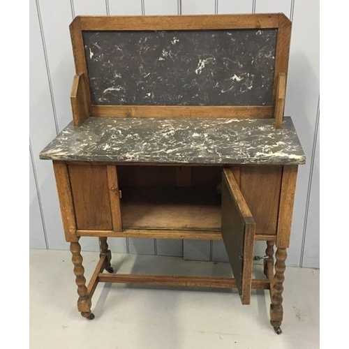 56 - An Edwardian oak wash stand, with marble top & raised back, over a single door cupboard area, raised... 