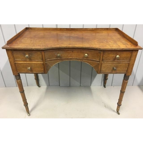 62 - A Georgian oak writing table. A central dished drawer over arched apron, flanked either side by a pa...