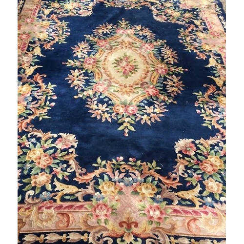 193 - A large 20th century Chinese rug, with a central floral medallion & outer frame, on a Royal blue bac... 