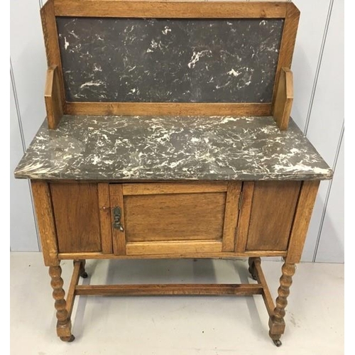 56 - An Edwardian oak wash stand, with marble top & raised back, over a single door cupboard area, raised... 